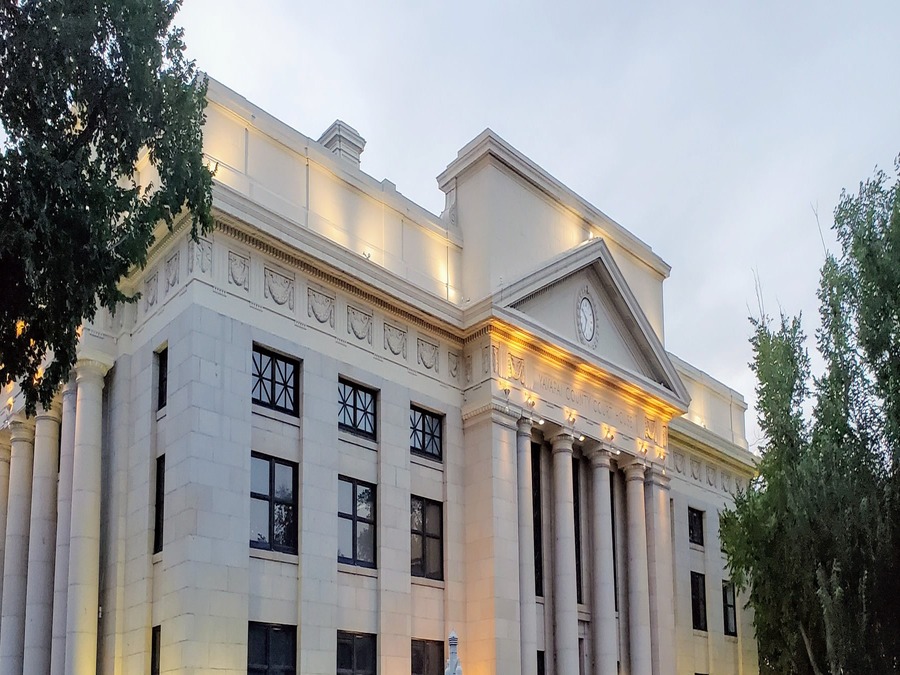 The Yavapai County Courthouse in downtown Prescott, Arizona, lit at dusk, with its columned facade and clock tower.